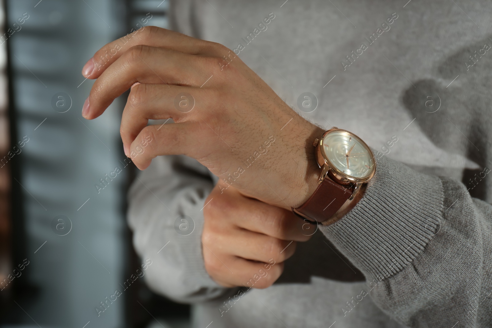 Photo of Man with luxury wrist watch on blurred background, closeup