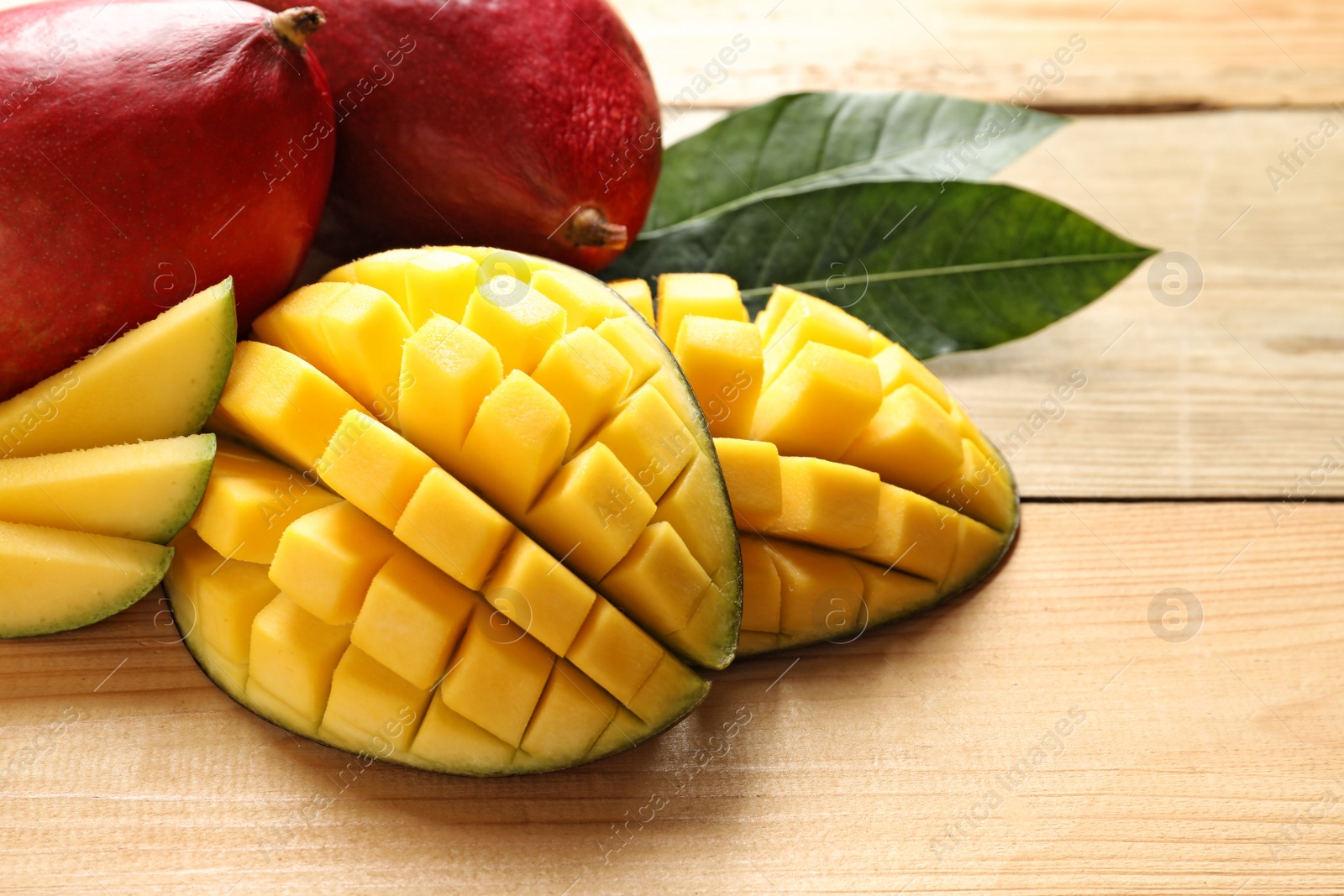 Photo of Composition with fresh mango on light wooden background, closeup