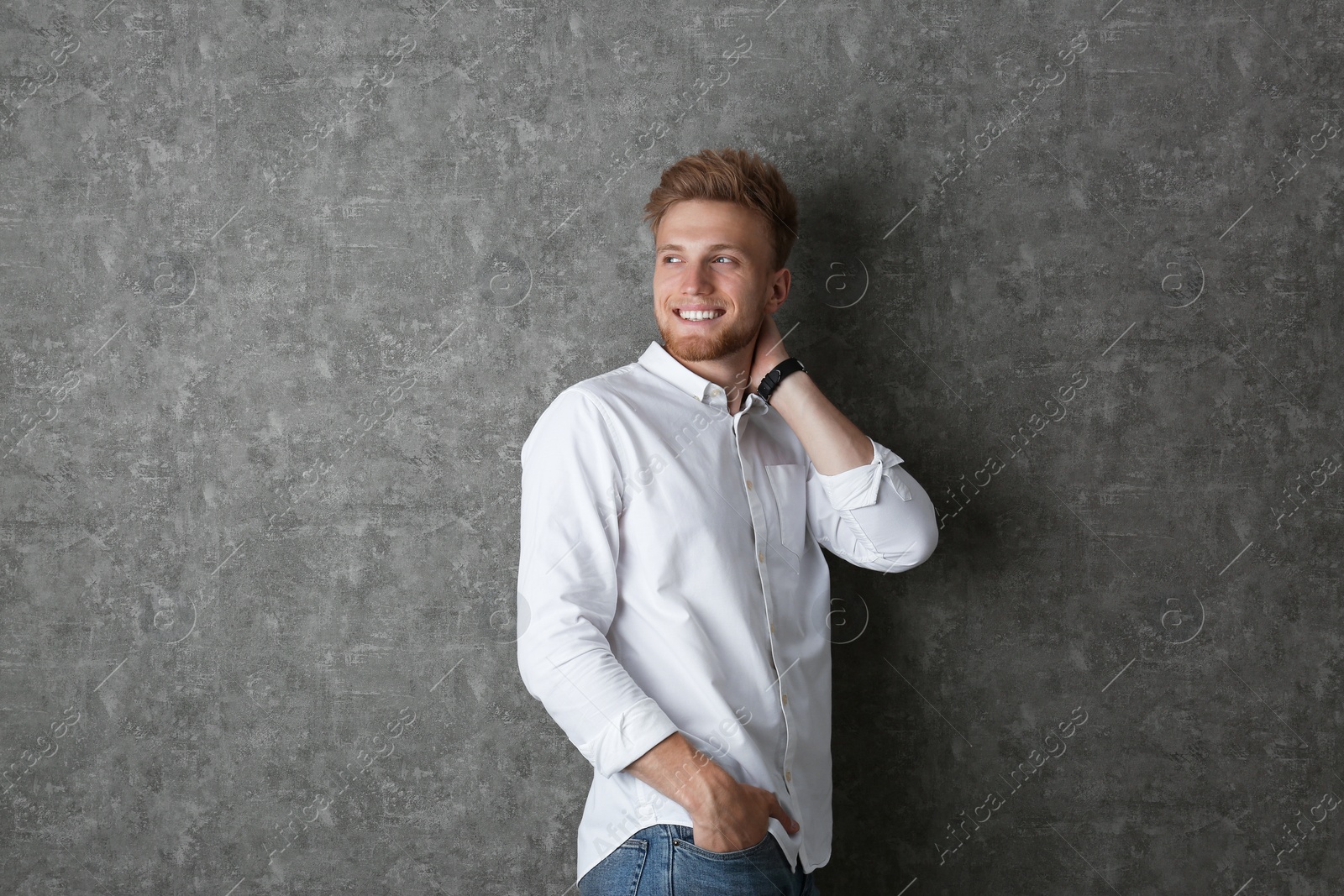 Photo of Portrait of handsome young man near grey wall