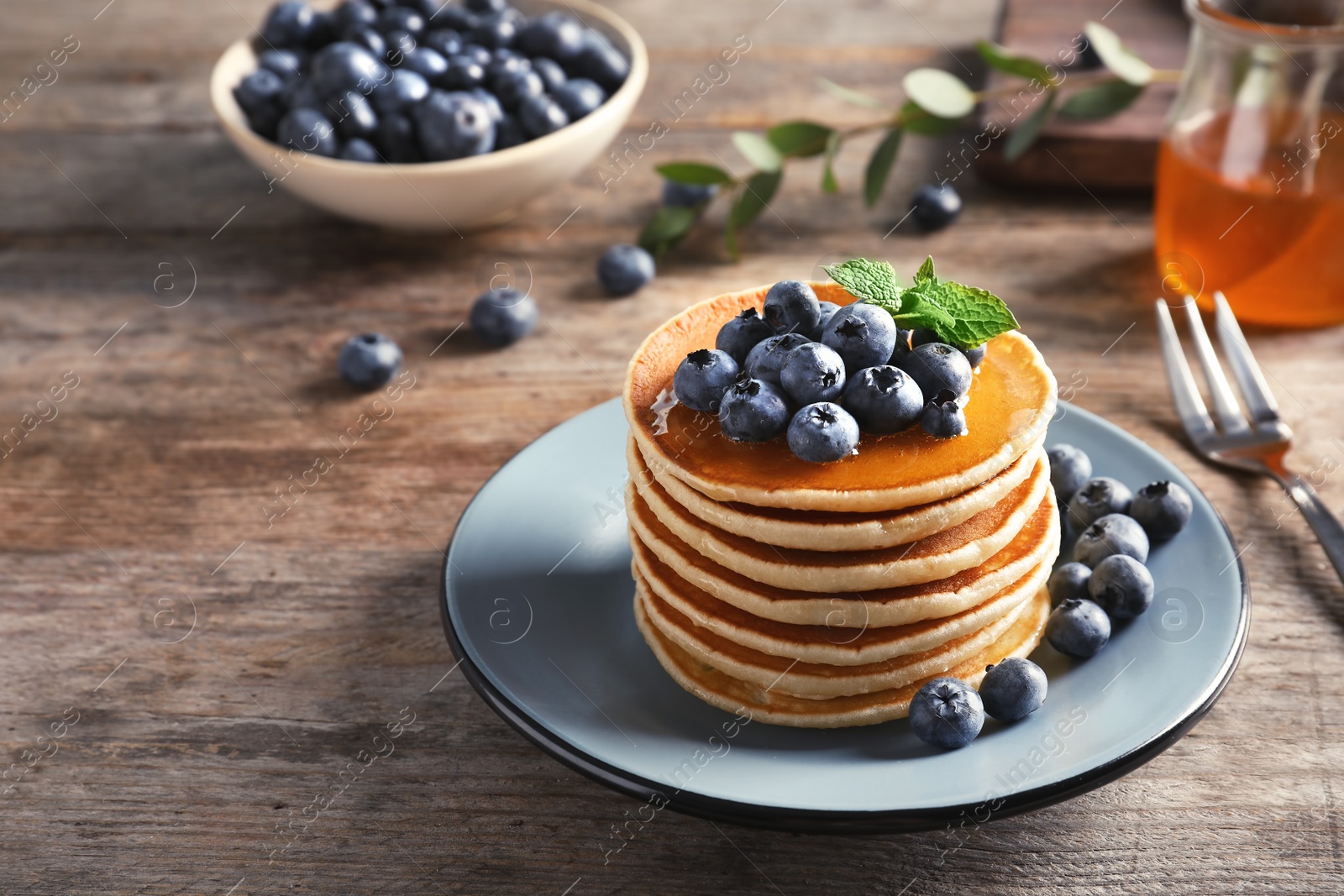 Photo of Plate with pancakes and berries on wooden table