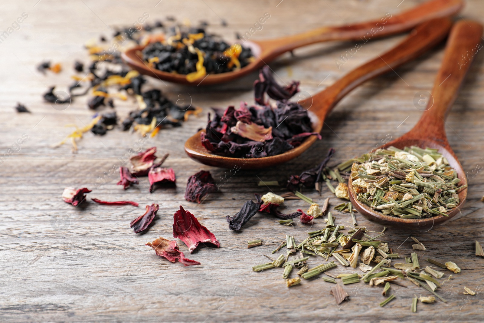 Photo of Composition with different teas and spoons on wooden table