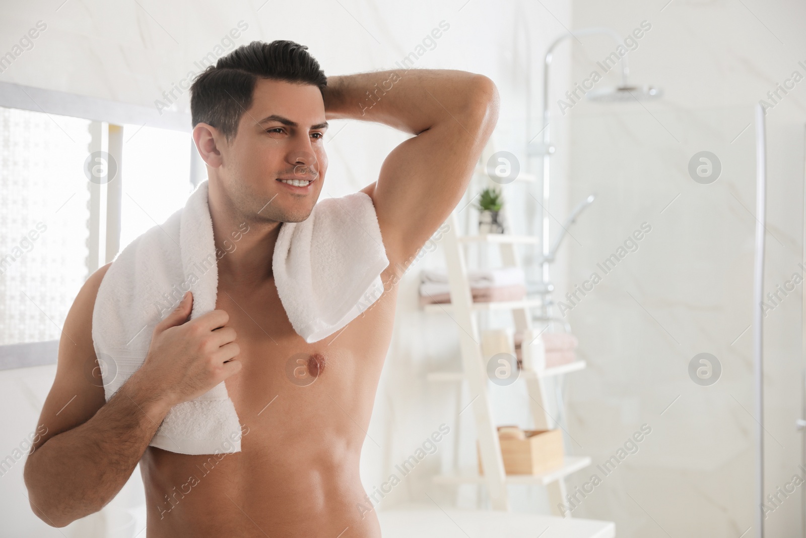 Photo of Handsome man with towel in bathroom after shaving