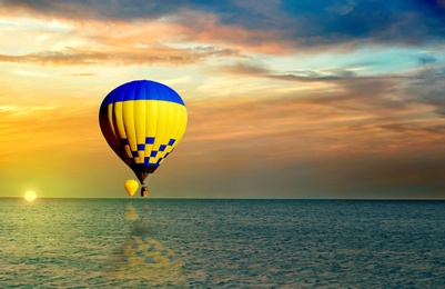 Image of Fantastic dreams. Hot air balloons in sunset sky with clouds over sea
