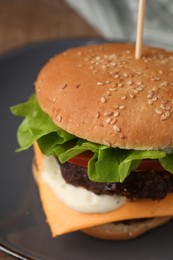 Photo of Tasty cheeseburger with patties on plate, closeup