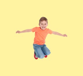 Image of Happy boy jumping on beige background, full length portrait