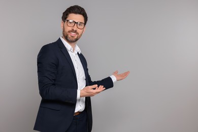 Happy real estate agent in glasses on grey background. Space for text