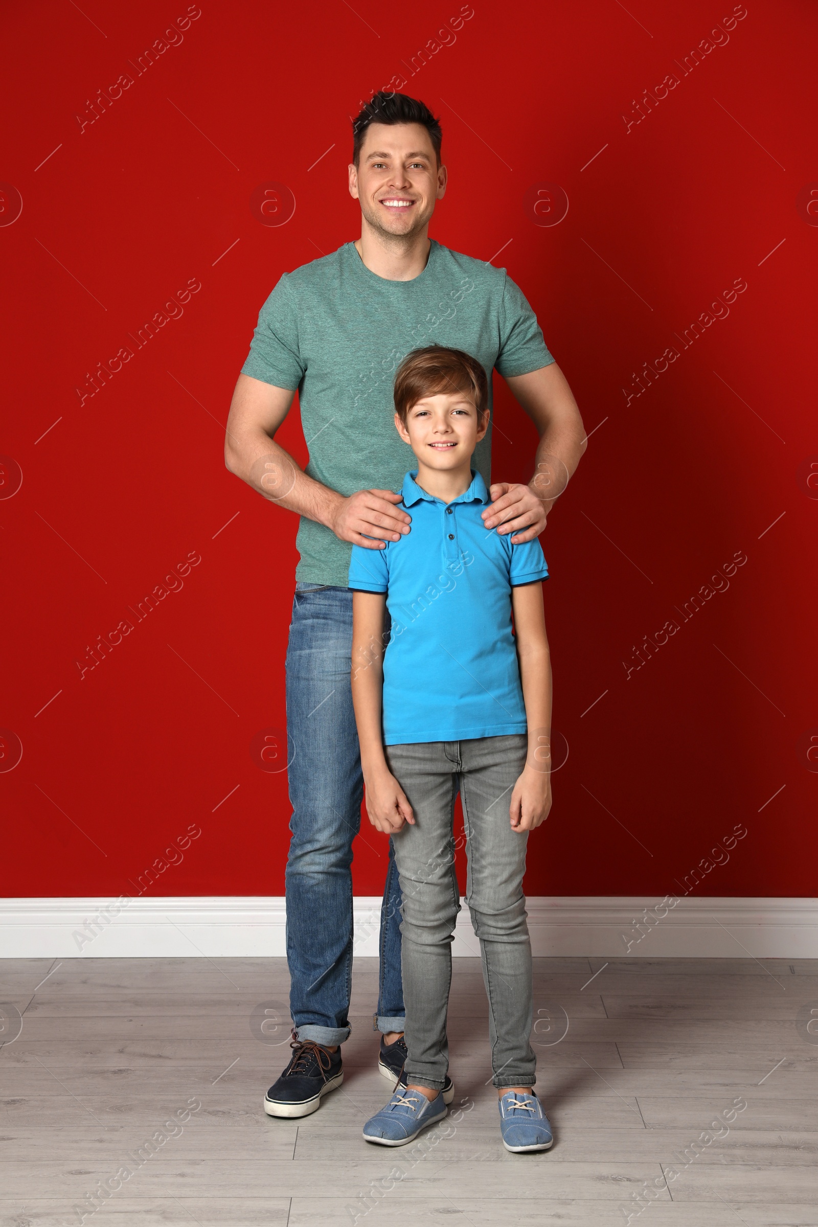 Photo of Portrait of dad and his son near color wall