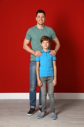 Portrait of dad and his son near color wall