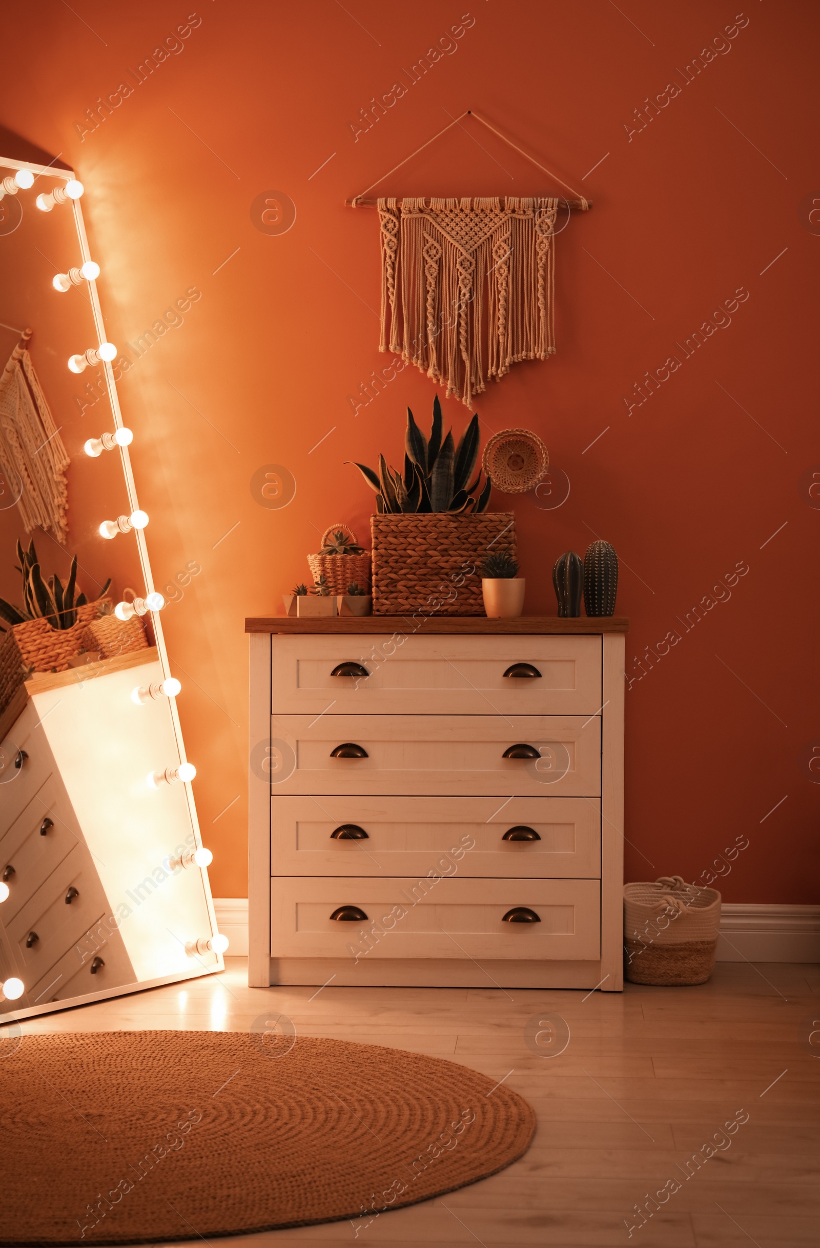 Photo of Large mirror with light bulbs and chest of drawers in stylish room interior