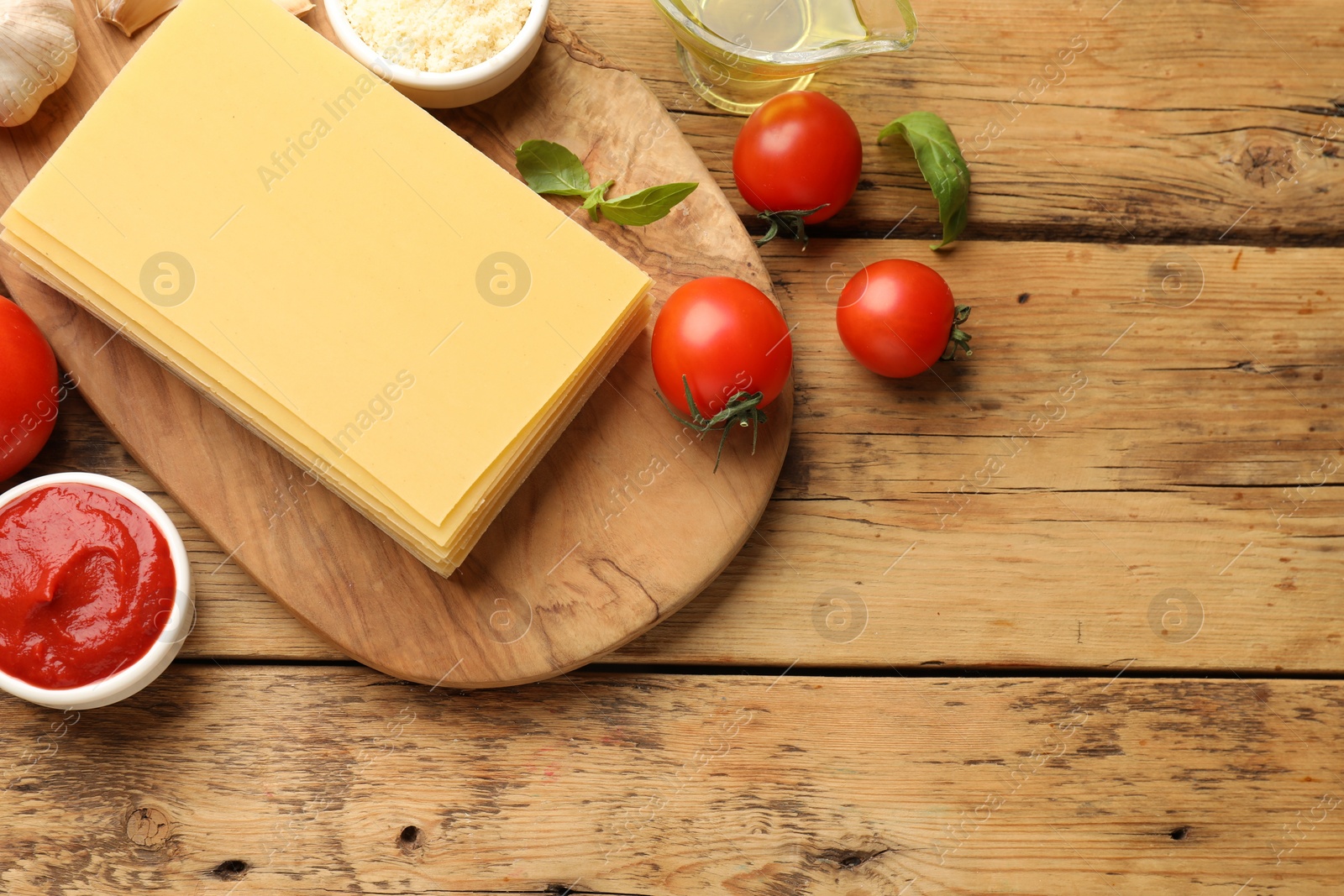 Photo of Flat lay composition with products for cooking lasagna on wooden table. Space for text