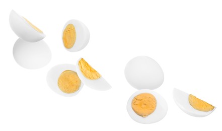 Image of Tasty hard boiled eggs falling on white background