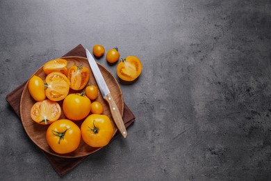 Photo of Fresh ripe yellow tomatoes on grey table, top view. Space for text
