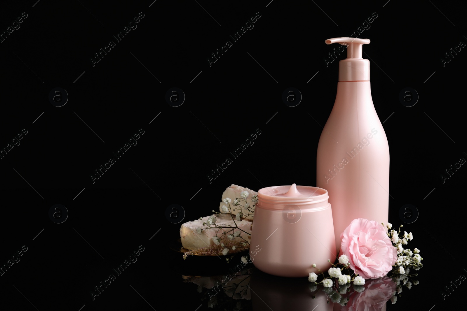 Photo of Hair cosmetic products and flowers on black background. Space for text