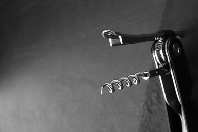 Photo of One corkscrew (sommelier knife) on grey table, closeup. Space for text