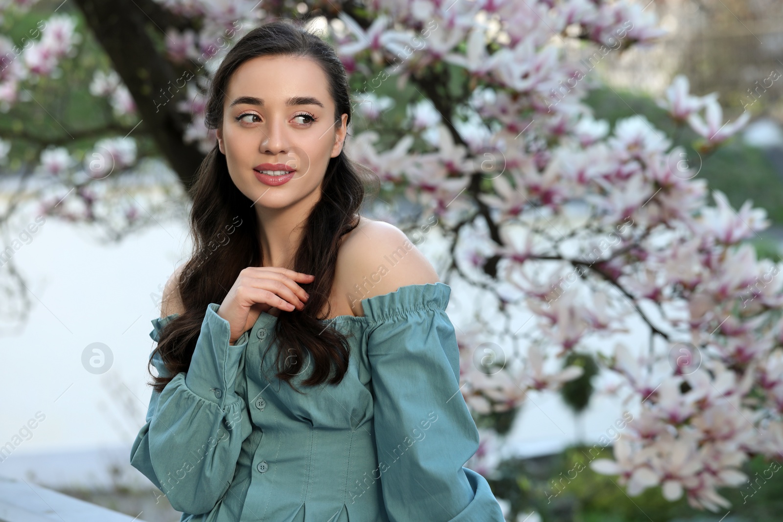 Photo of Beautiful woman near blossoming magnolia tree on spring day