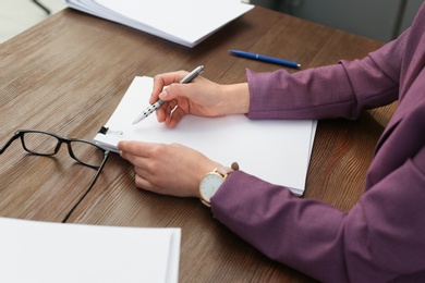 Businesswoman working with documents at office table, closeup