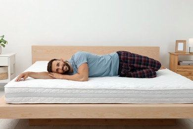 Photo of Happy man on bed with comfortable mattress at home