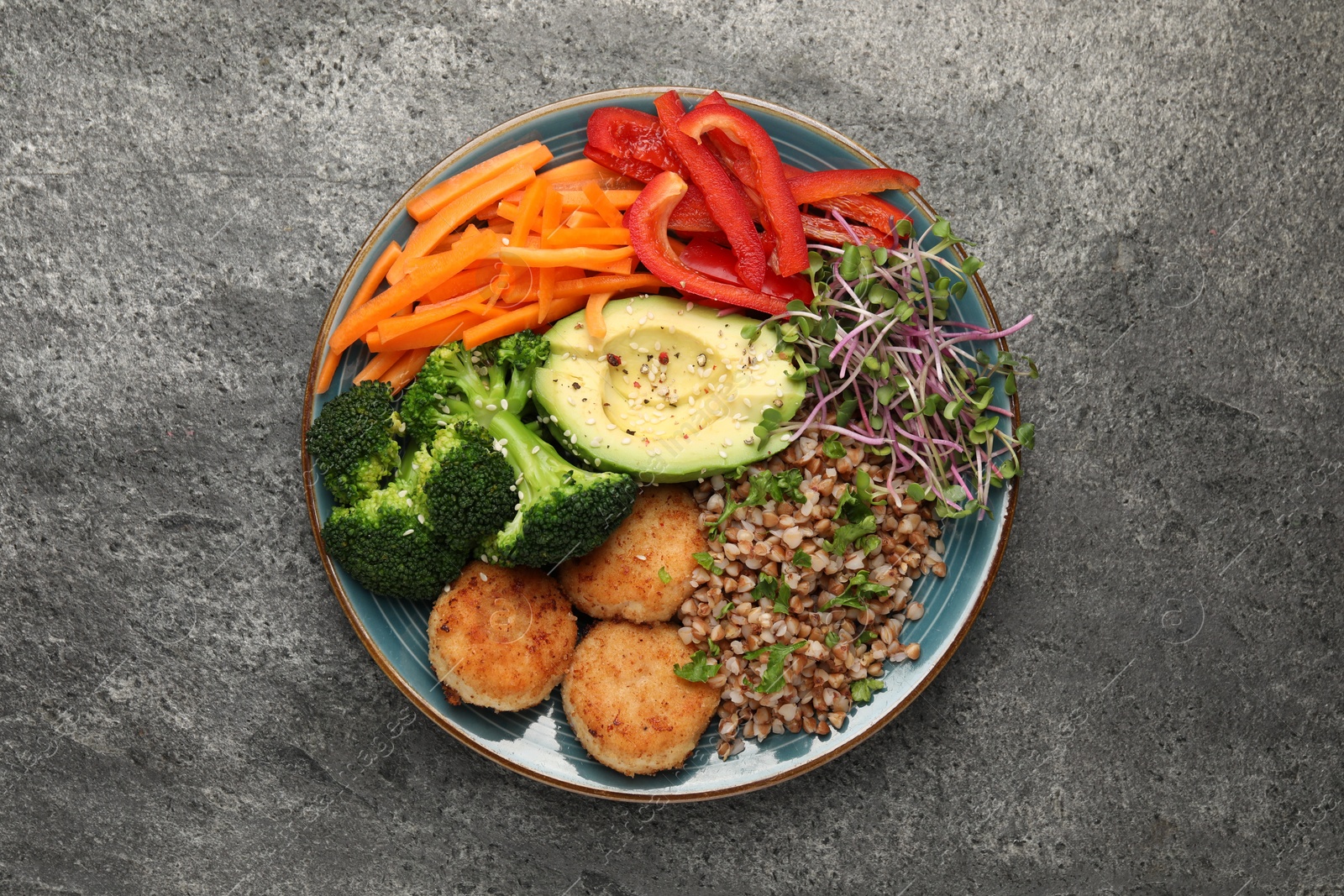 Photo of Delicious vegan bowl with cutlets, buckwheat and broccoli on grey table, top view