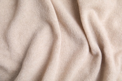 Warm cashmere sweater as background, top view