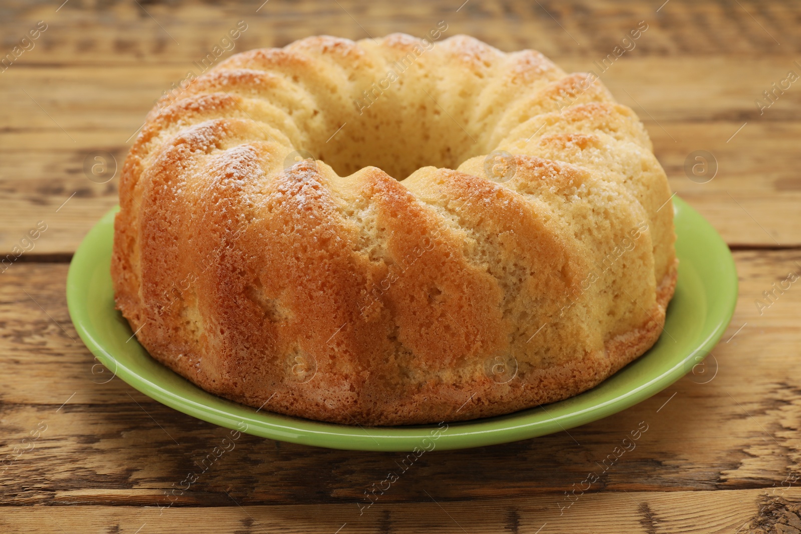 Photo of Delicious freshly baked sponge cake on wooden table, closeup