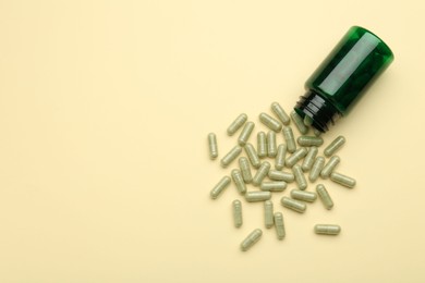 Photo of Vitamin pills and bottle on beige background, top view. Space for text