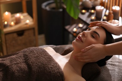 Photo of Spa therapy. Beautiful young woman lying on table during massage in salon