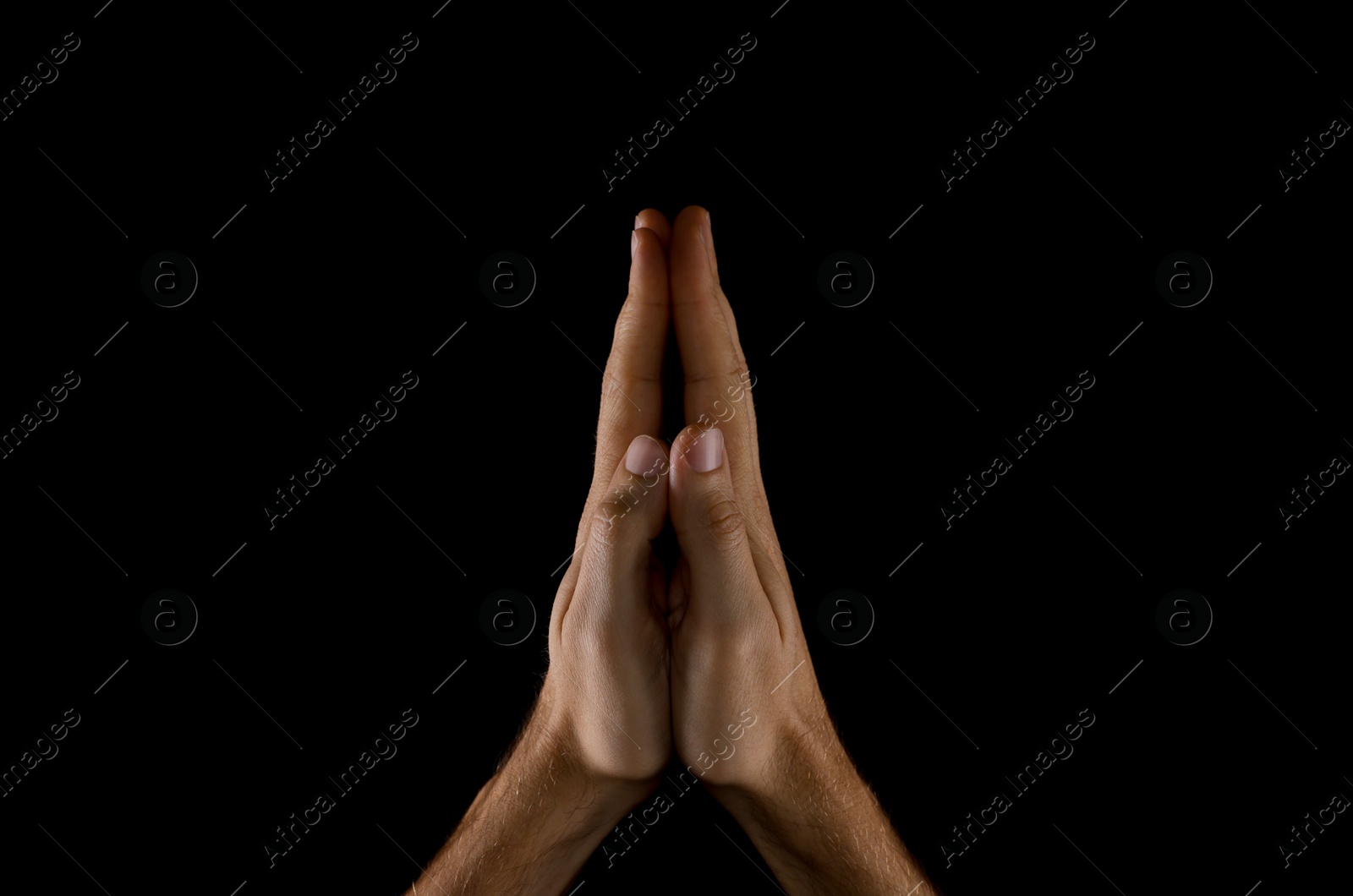 Photo of Man praying against black background, closeup view