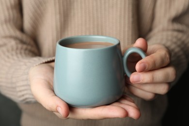 Photo of Woman holding cup of delicious hot cocoa, closeup