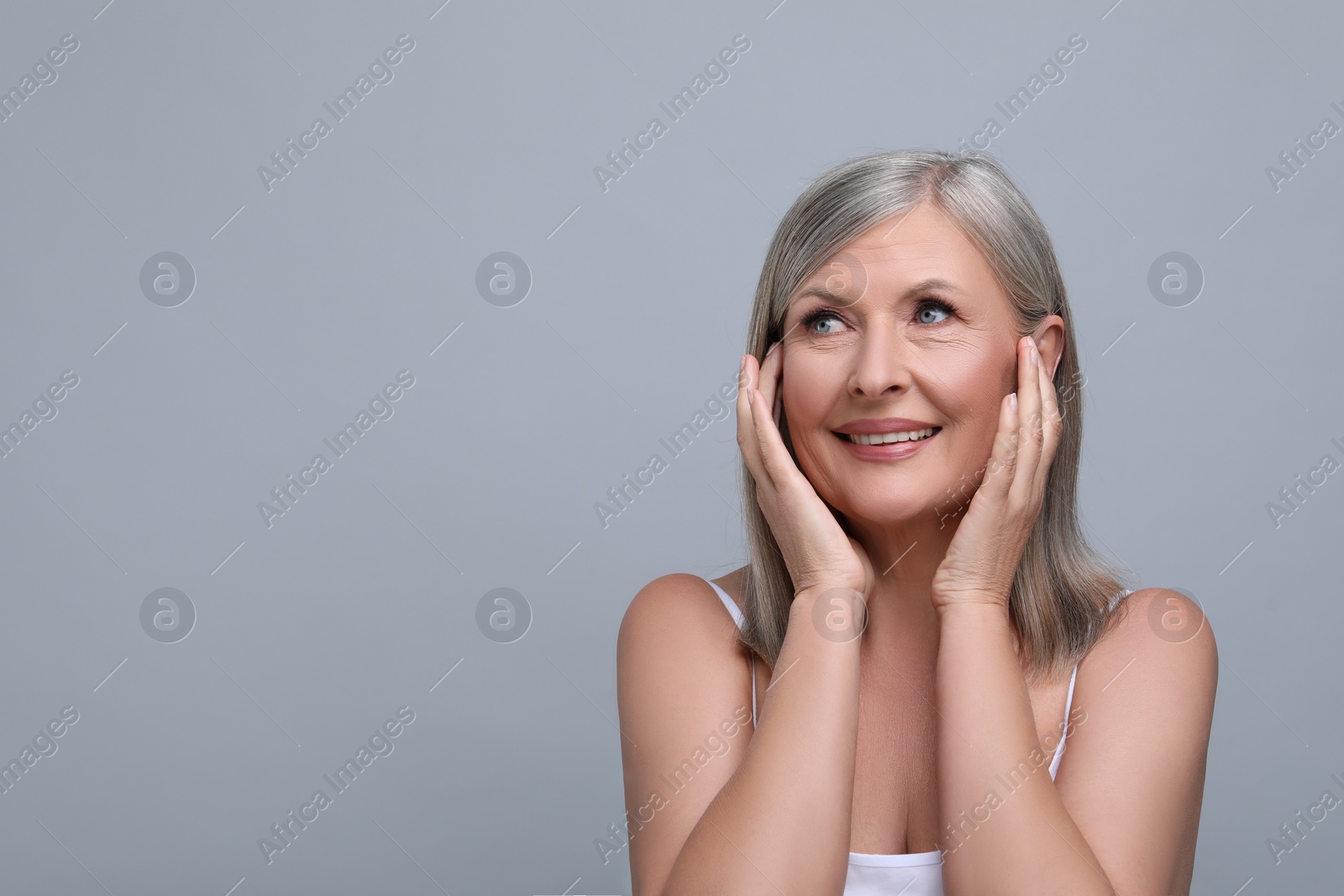 Photo of Portrait of beautiful senior woman on grey background. Space for text