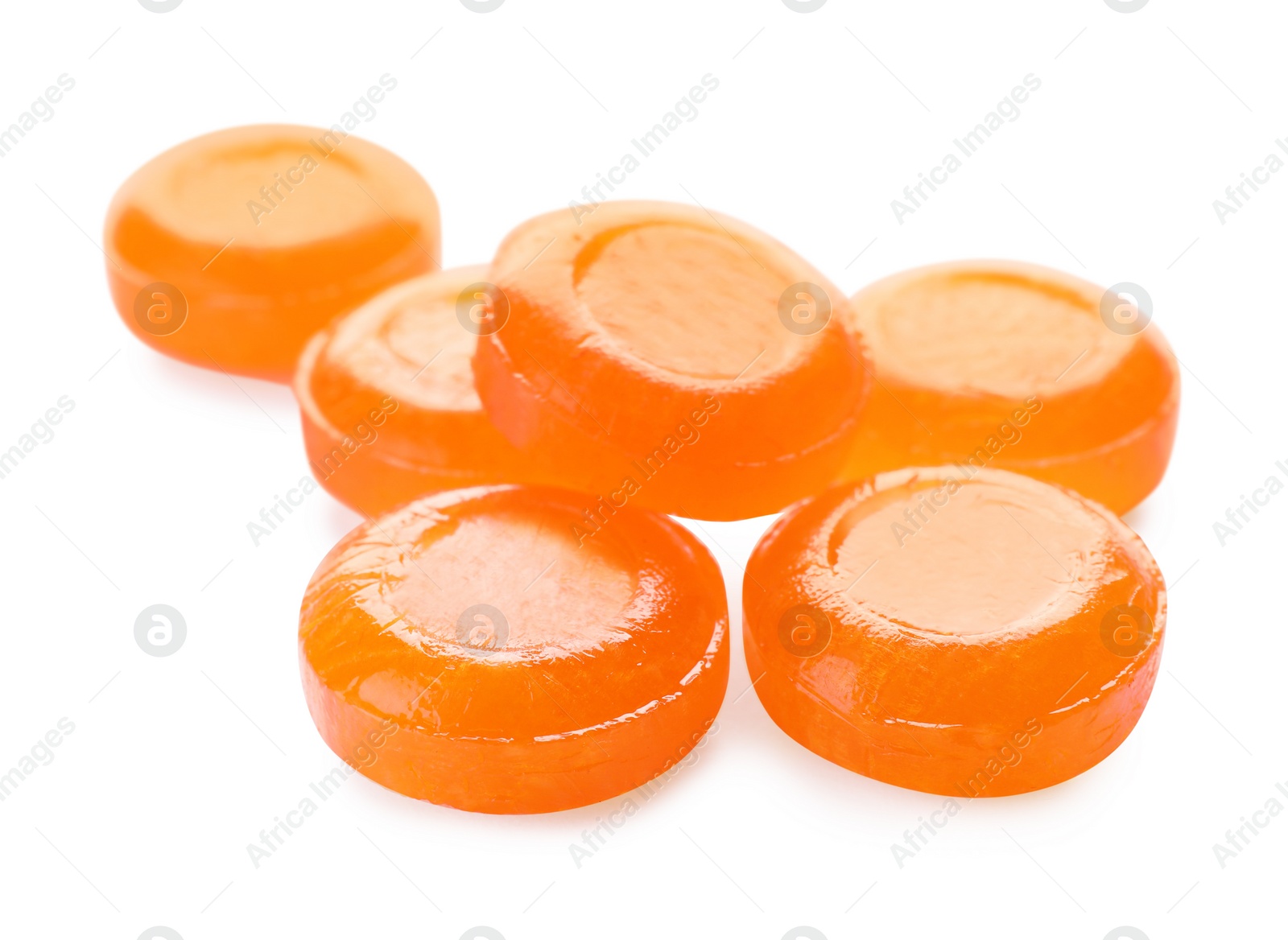 Photo of Many orange cough drops on white background