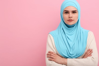 Photo of Portrait of Muslim woman in hijab on pink background, space for text