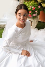 Photo of Young bride wearing beautiful wedding dress outdoors