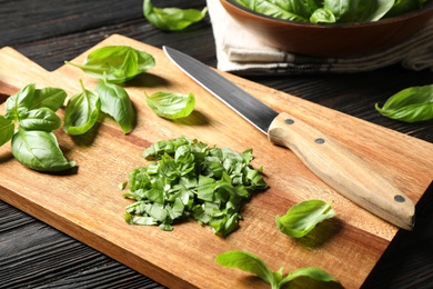 Photo of Fresh green basil on black wooden table
