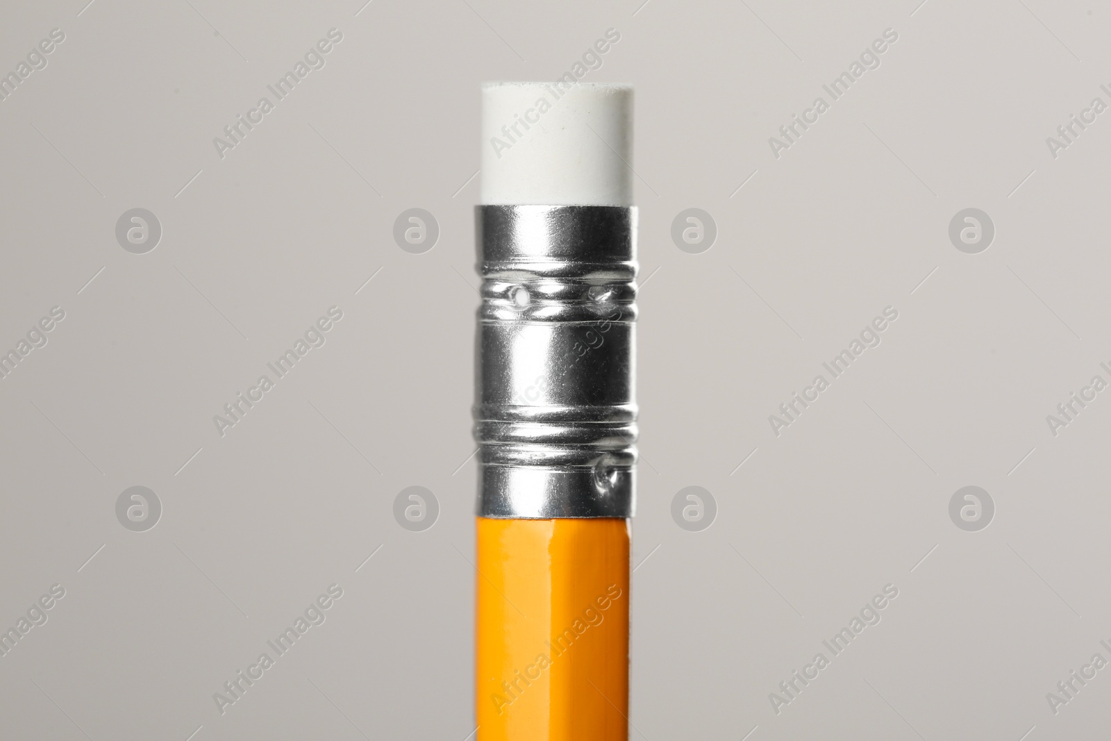 Photo of Graphite pencil with eraser on grey background, macro view