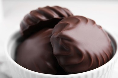 Photo of Delicious chocolate covered zephyrs in bowl, closeup