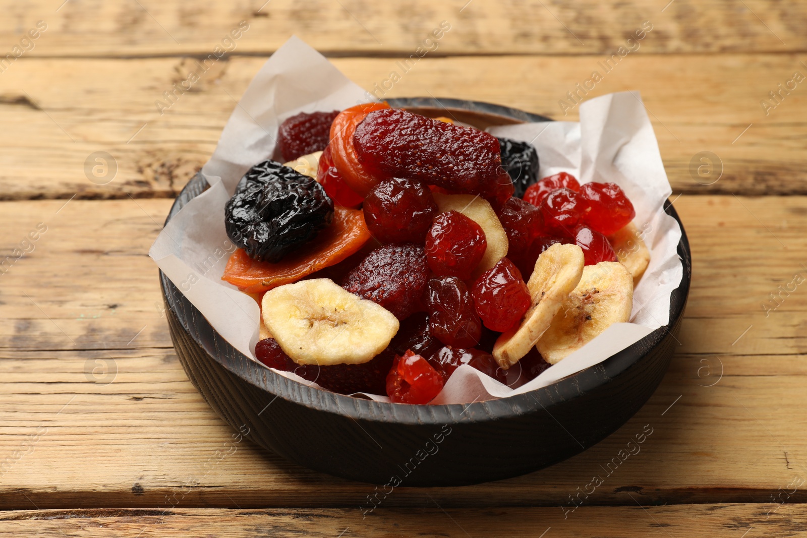 Photo of Mix of delicious dried fruits on wooden table, closeup