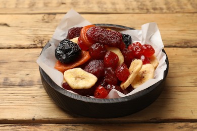 Photo of Mix of delicious dried fruits on wooden table, closeup