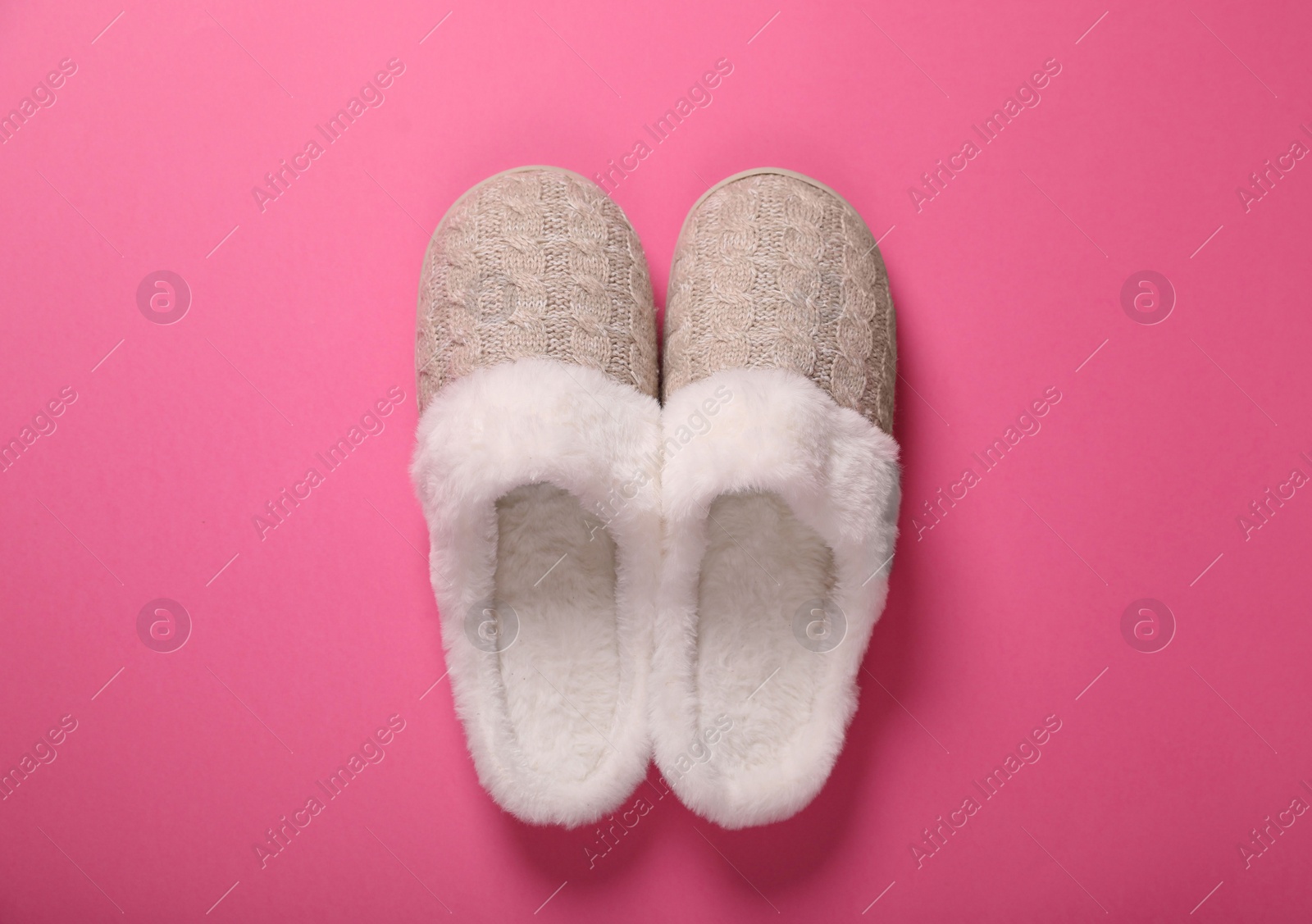 Photo of Pair of beautiful soft slippers on pink background, top view