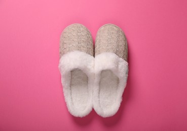 Photo of Pair of beautiful soft slippers on pink background, top view