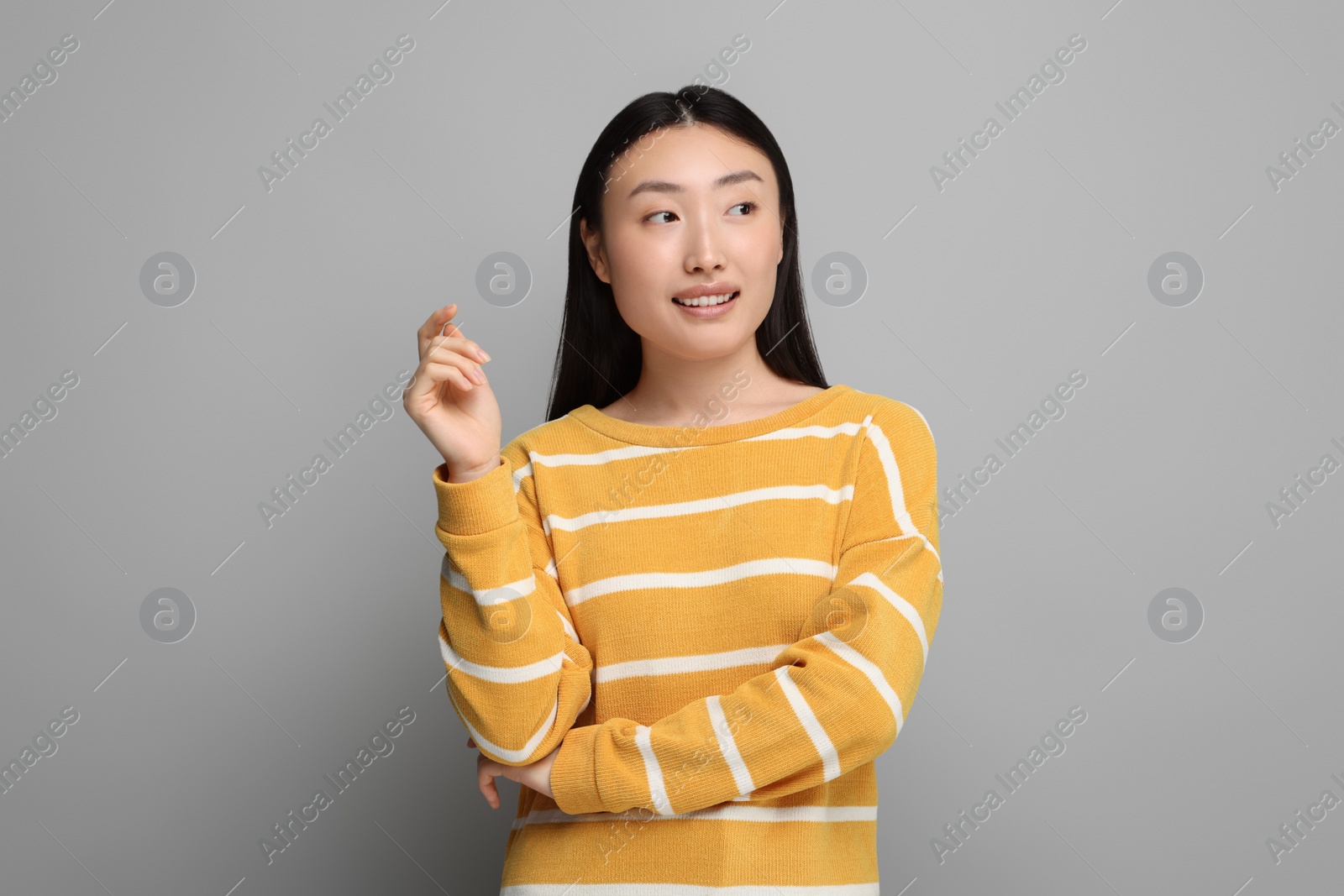 Photo of Portrait of smiling woman on grey background