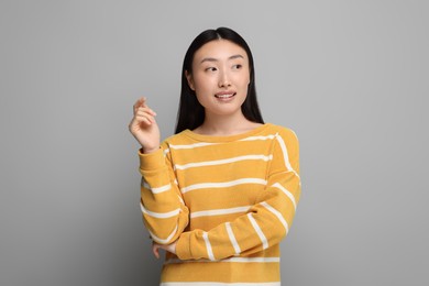 Photo of Portrait of smiling woman on grey background