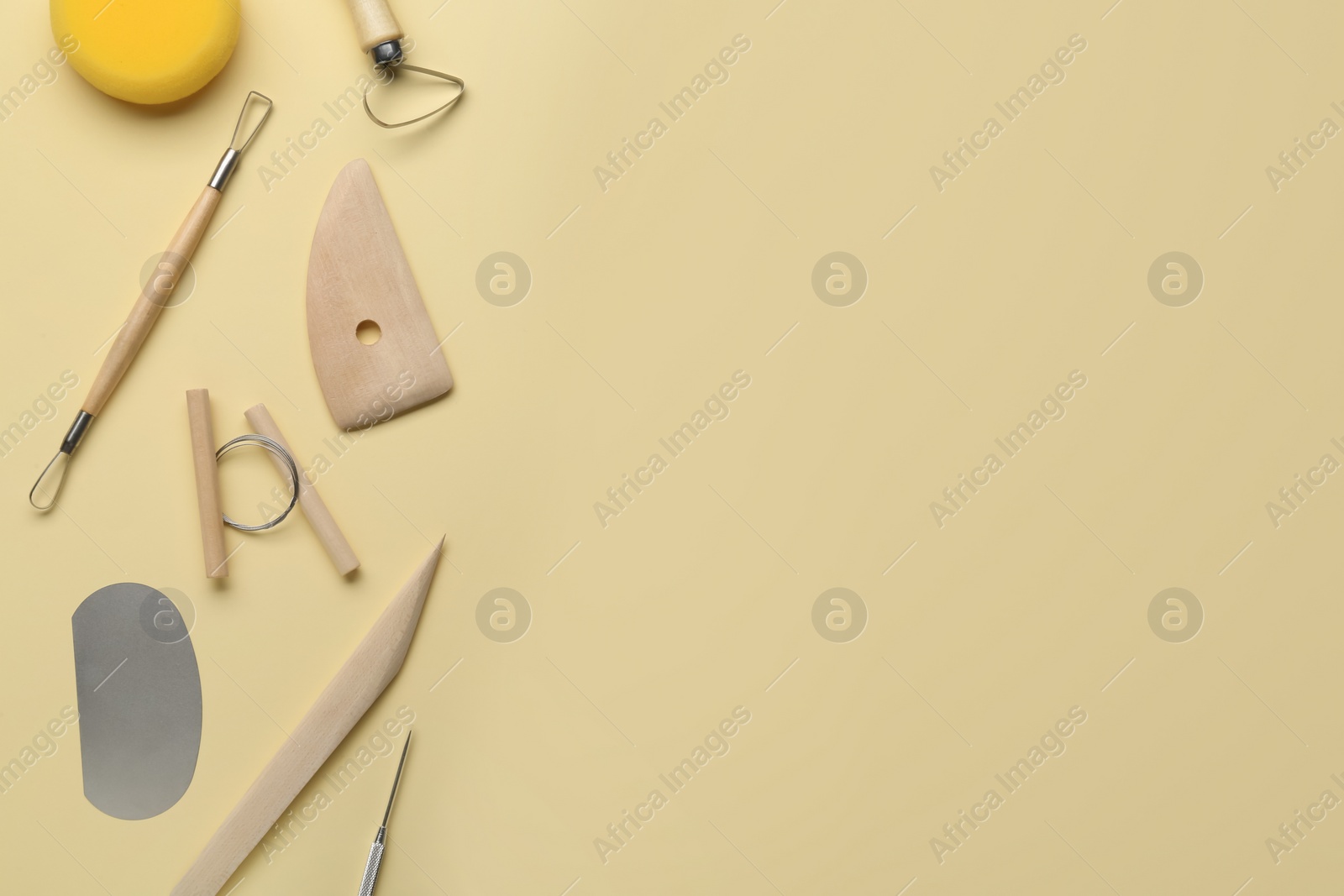 Photo of Set of clay modeling tools on beige background, flat lay. Space for text