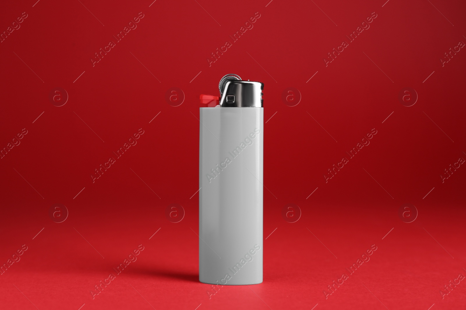 Photo of Stylish small pocket lighter on red background