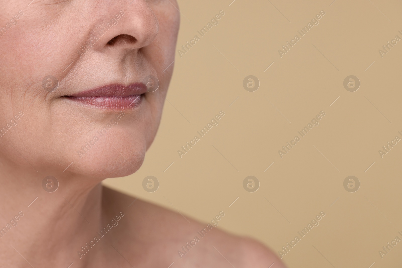 Photo of Senior woman with aging skin on beige background, closeup and space for text. Rejuvenation treatment