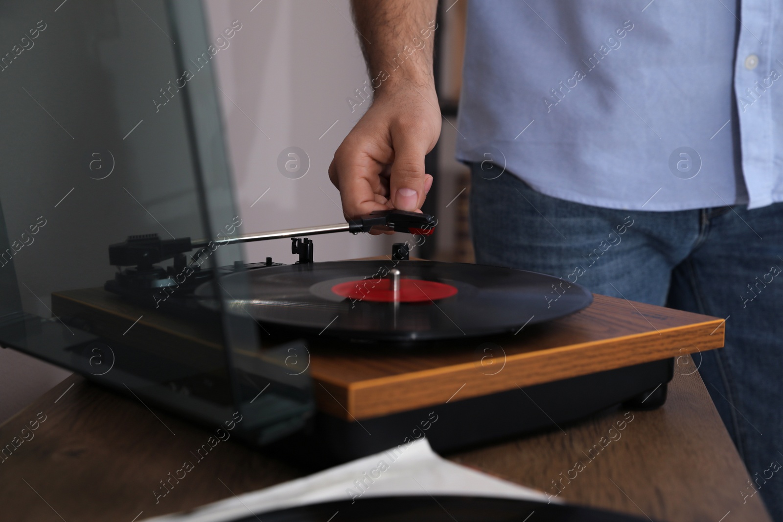 Photo of Man using turntable at home, closeup view