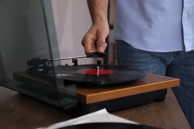 Photo of Man using turntable at home, closeup view