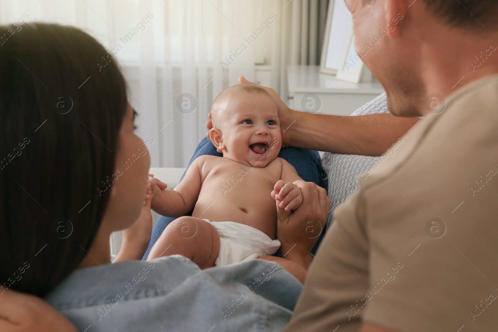 Photo of Happy family with their cute baby at home