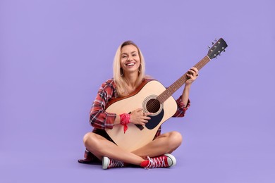 Photo of Happy hippie woman playing guitar on purple background