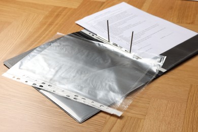 Photo of File folder with punched pockets on wooden table