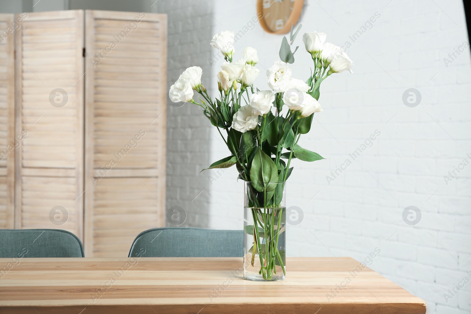 Photo of Vase with beautiful flowers as element of interior design on table in room. Space for text